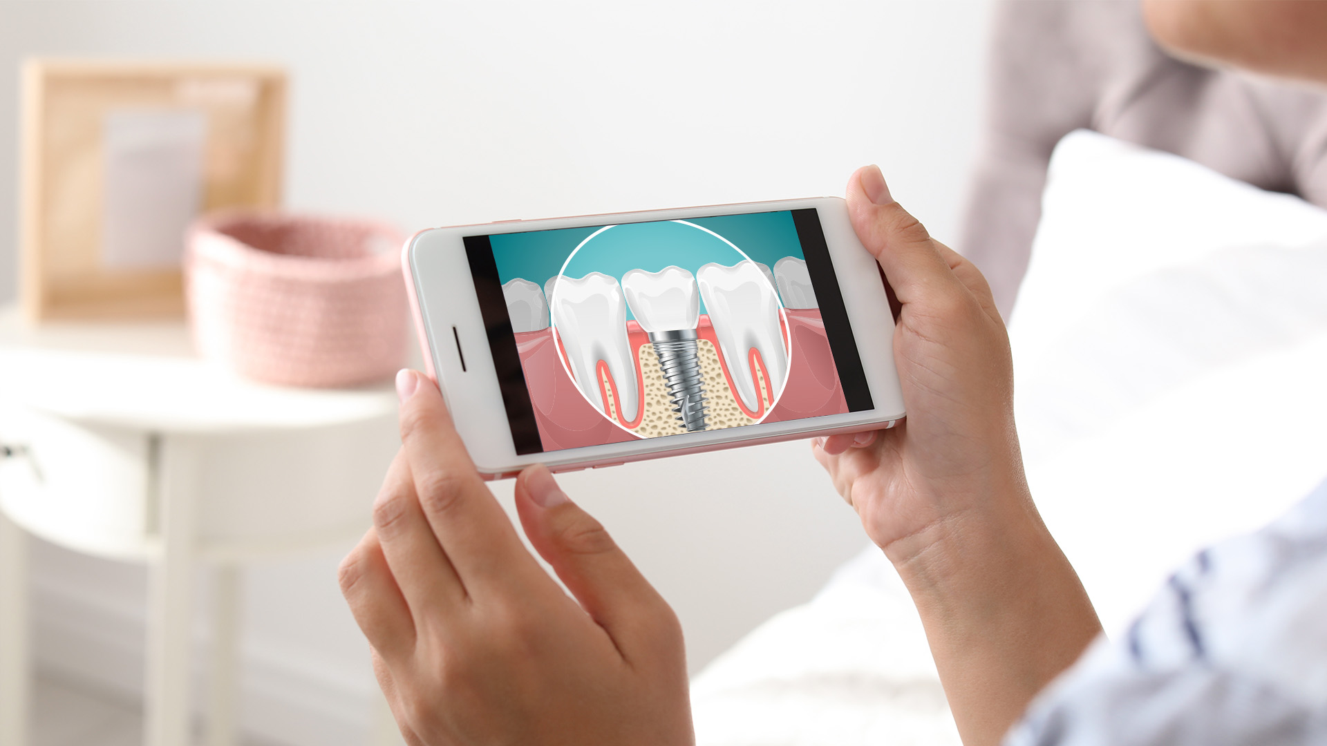 A person holding a smartphone displaying an illustration of a tooth with a cavity being filled.