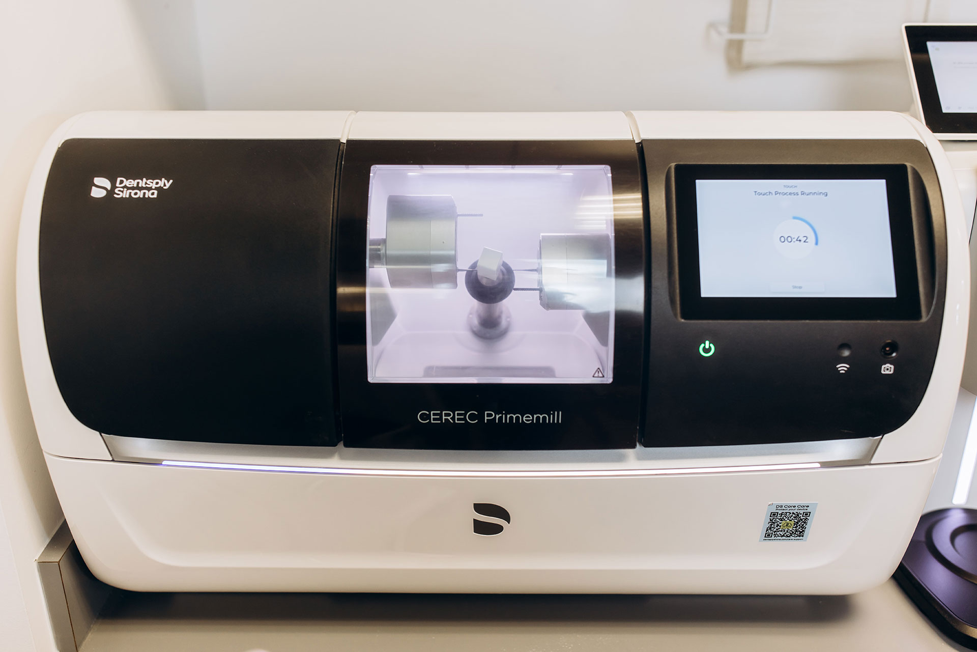 The image shows a modern 3D printer with a digital interface and a partially printed object on its bed, suggesting the use of advanced technology for manufacturing purposes.