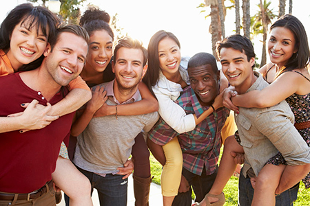 A group of young adults posing together for a photograph with smiles on their faces.